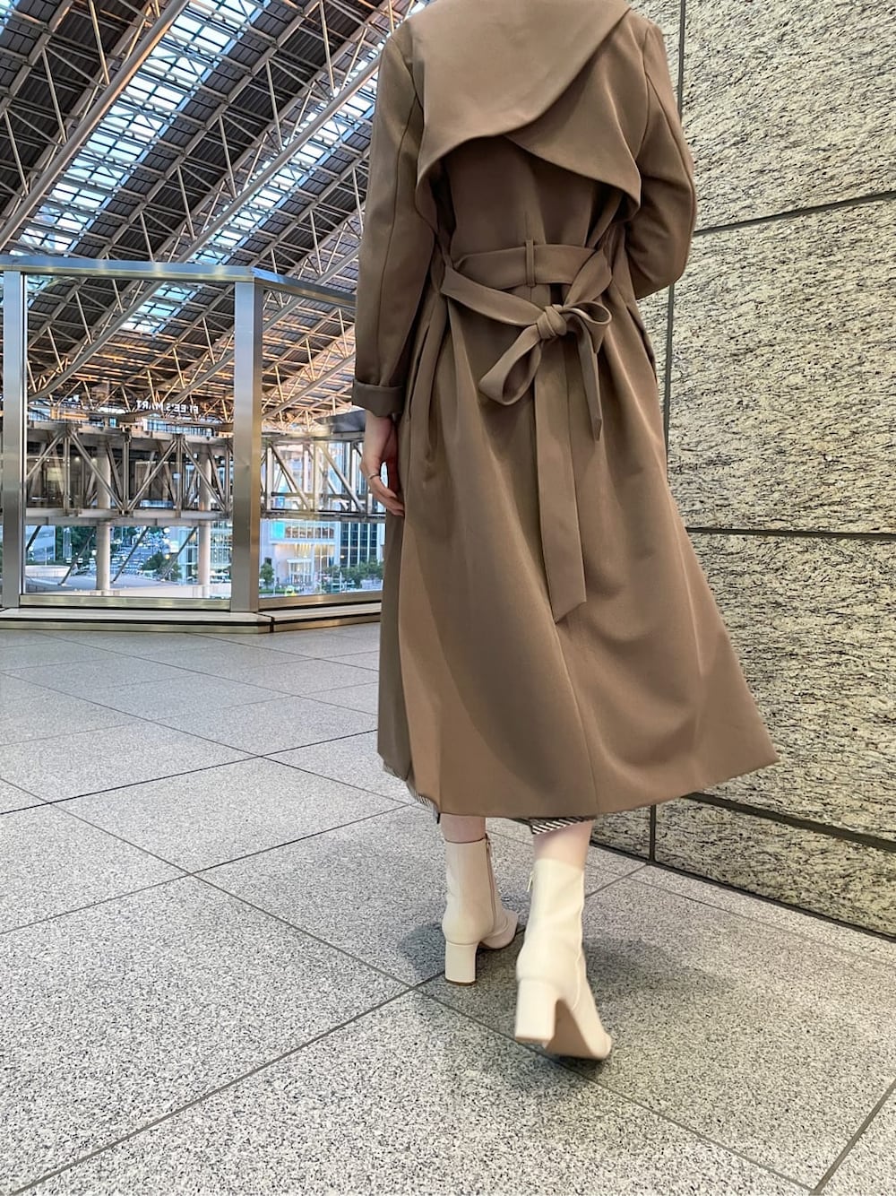 ホワイト系のその他シューズ、ブラック系のニット/セーター、ベージュ系のノーカラーコートを着用したレディースの冬コーディネートの2枚目の写真