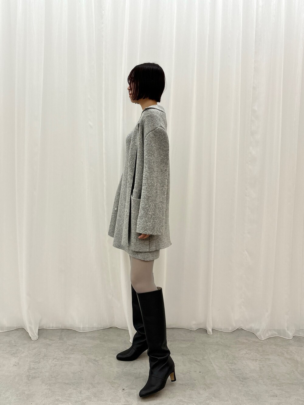 グレー系のワンピース、グレー系のテーラードジャケットを着用したレディースの秋コーディネートの3枚目の写真