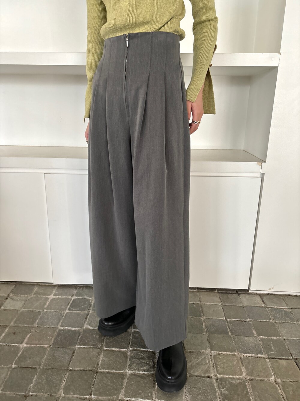 ブラック系のブーツ、グレー系のその他パンツ、グリーン系のニット/セーターを着用したレディースの冬コーディネートの7枚目の写真