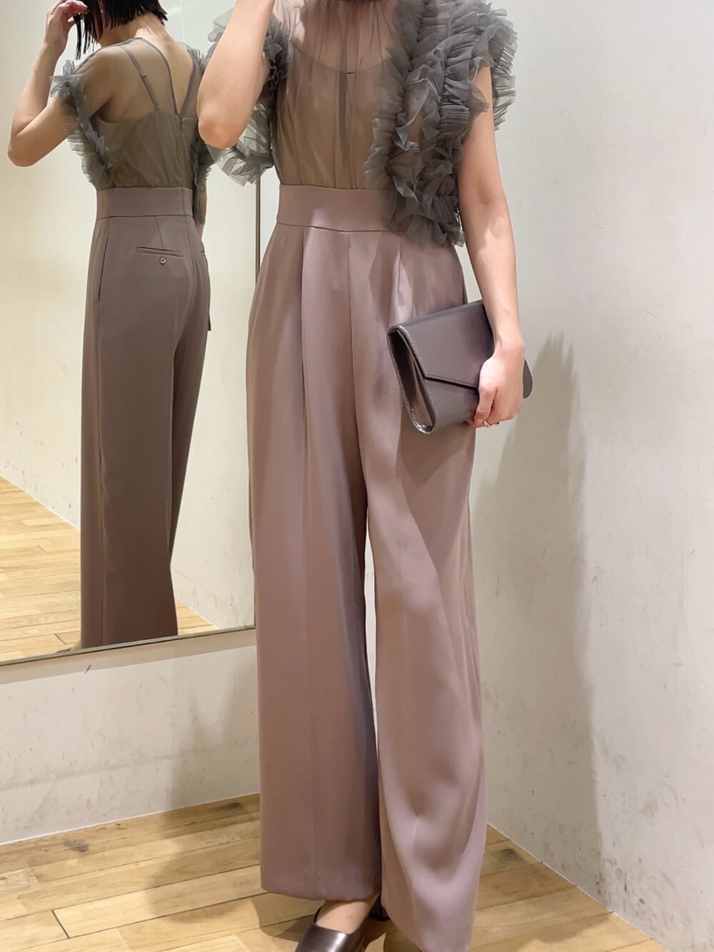 シルバー系のハンドバッグ、ピンク系のパンツドレス、その他のパンプスを着用したレディースの冬コーディネートの5枚目の写真