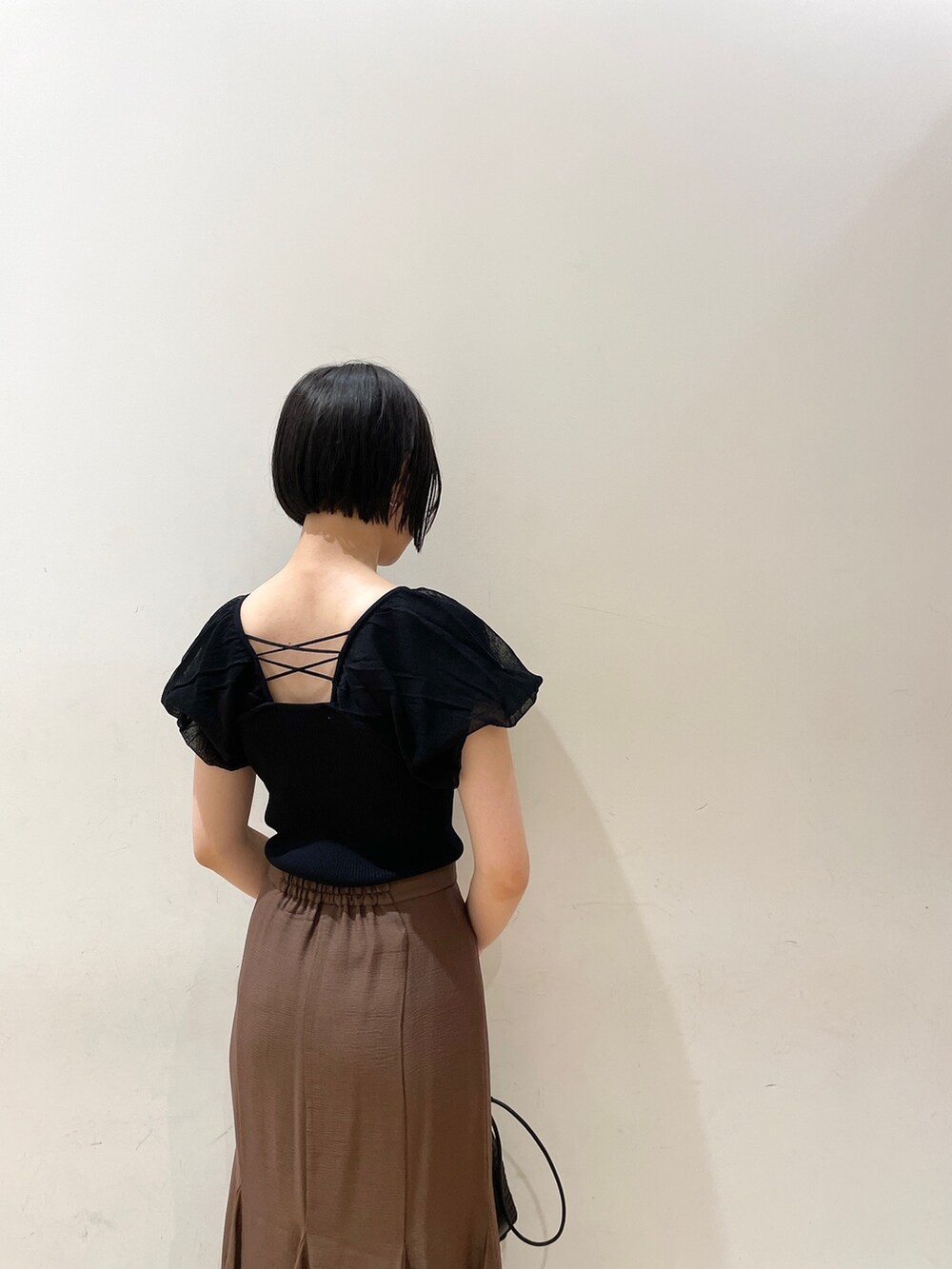 ブラウン系のスカート、ブラウン系のサンダル、ブラック系のハンドバッグを着用したレディースの夏コーディネートの7枚目の写真