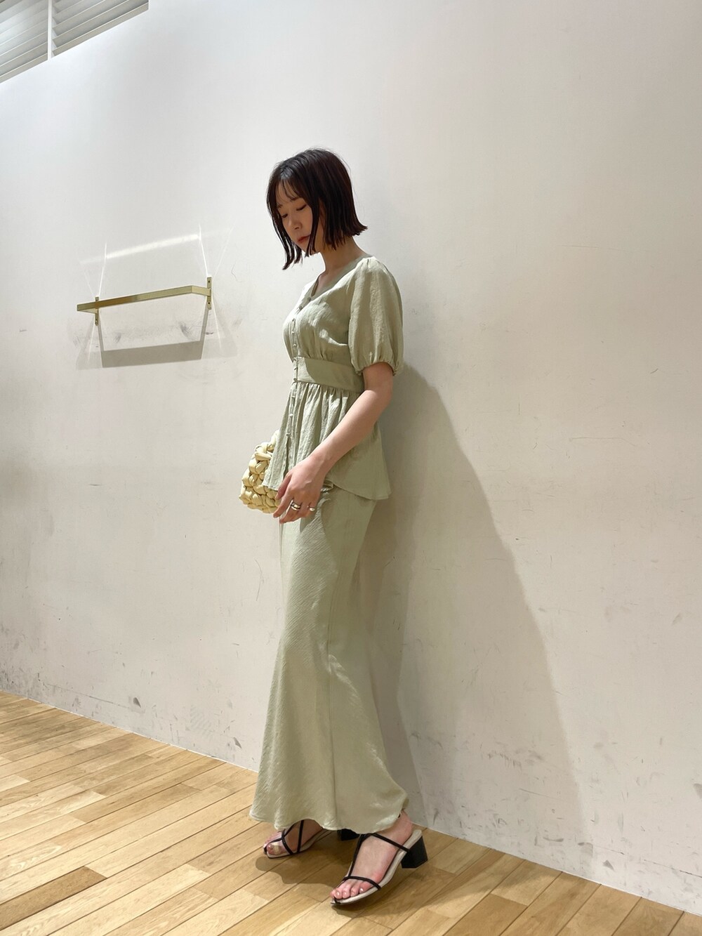 ベージュ系のハンドバッグ、ブラック系のサンダル、グリーン系のスカートを着用したレディースの夏コーディネートの3枚目の写真