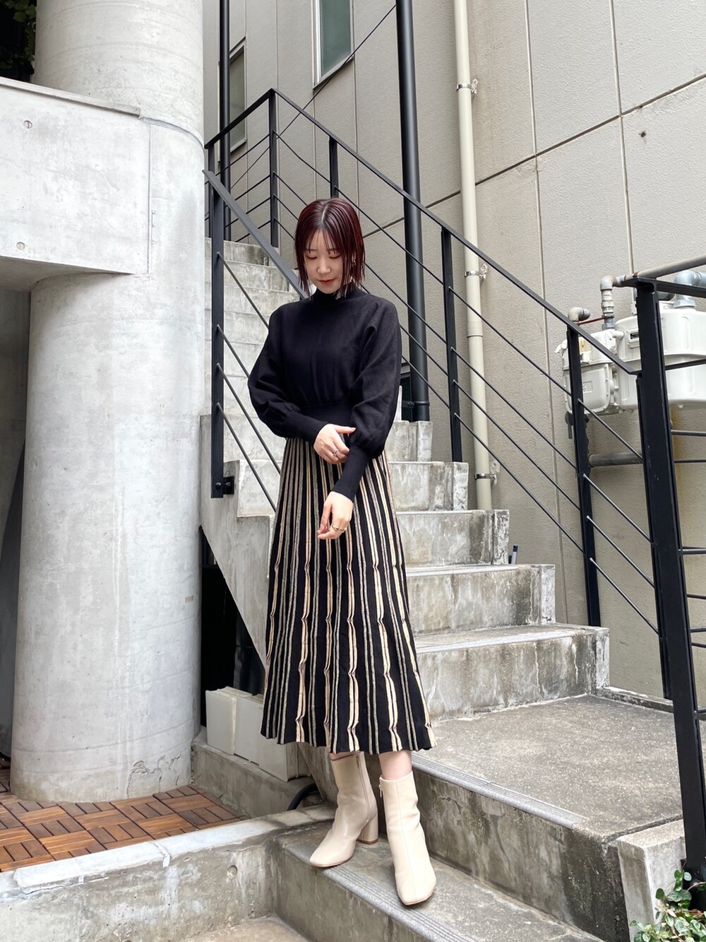 ホワイト系のブーツ、ブラック系のワンピース、グレー系のノーカラーコートを着用したレディースの冬コーディネートの2枚目の写真