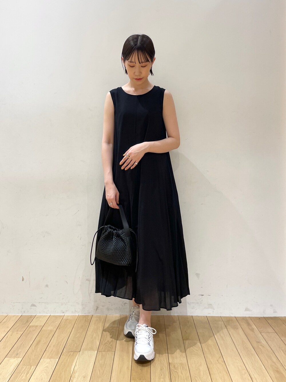 ブラック系のハンドバッグ、ベージュ系のテーラードジャケット、ブラック系のワンピースを着用したレディースの夏コーディネートの2枚目の写真