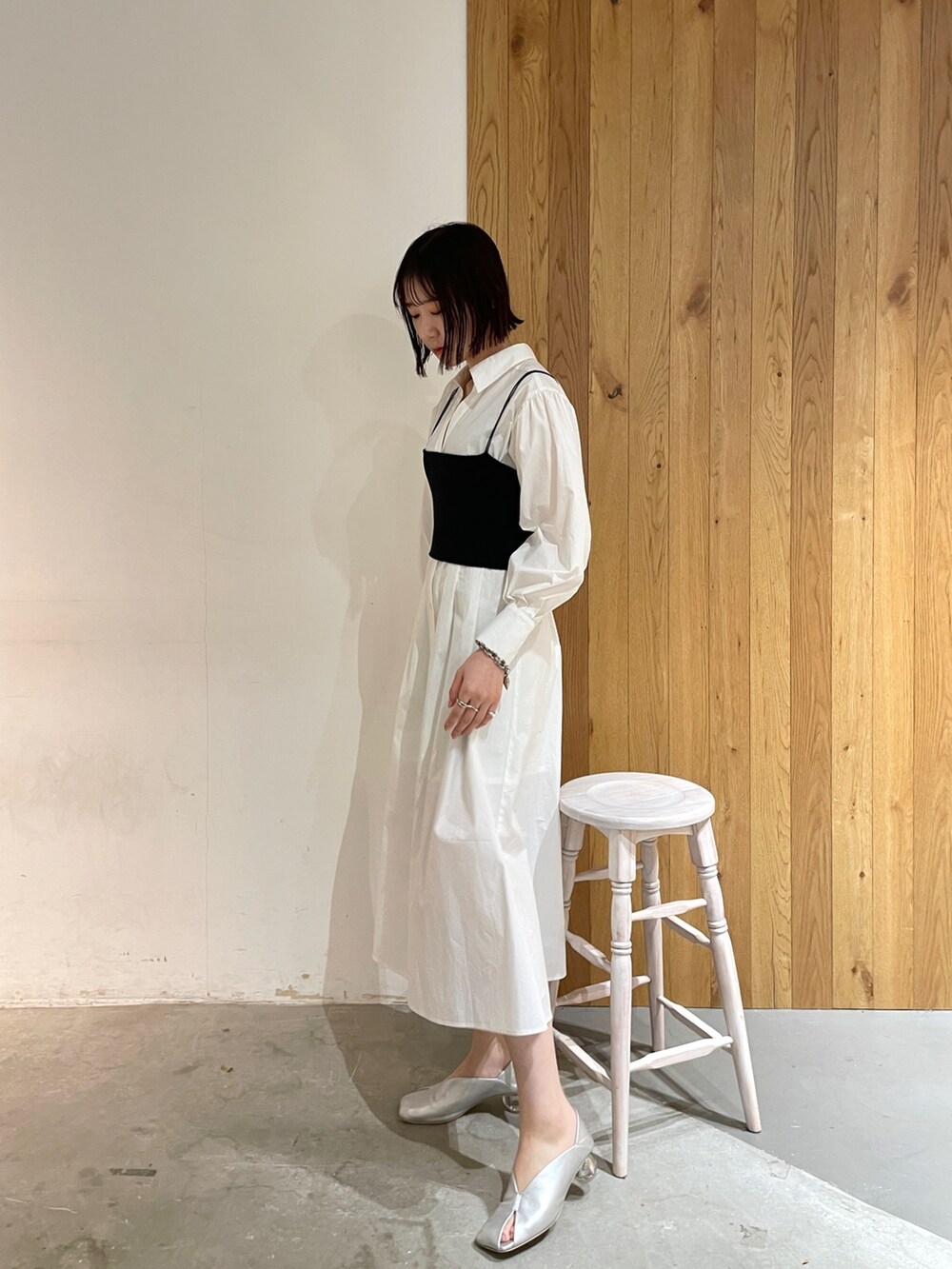 シルバー系のパンプス、ホワイト系のシャツワンピース、ブラック系のデニムジャケットを着用したレディースの冬コーディネートの3枚目の写真