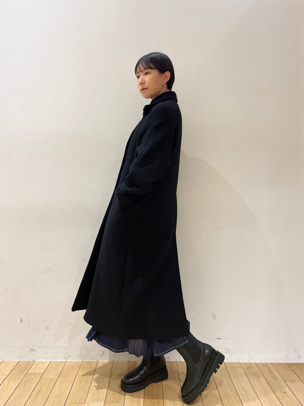 ブラック系のその他アウター、ホワイト系のニット/セーター、ブルー系のスカートを着用したレディースの冬コーディネートの8枚目の写真