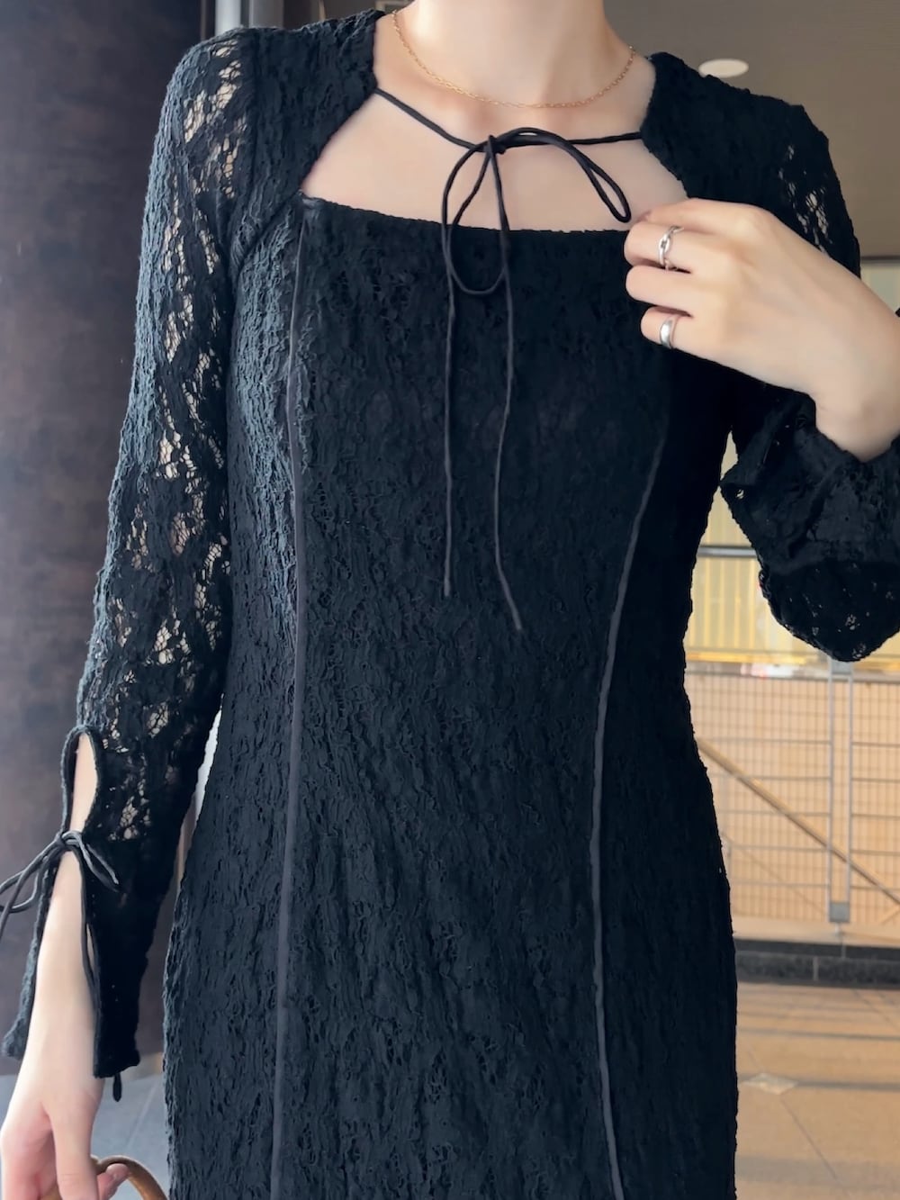 ブラック系のワンピース、イエロー系のハンドバッグ、シルバー系のパンプスを着用したレディースの冬コーディネートの7枚目の写真