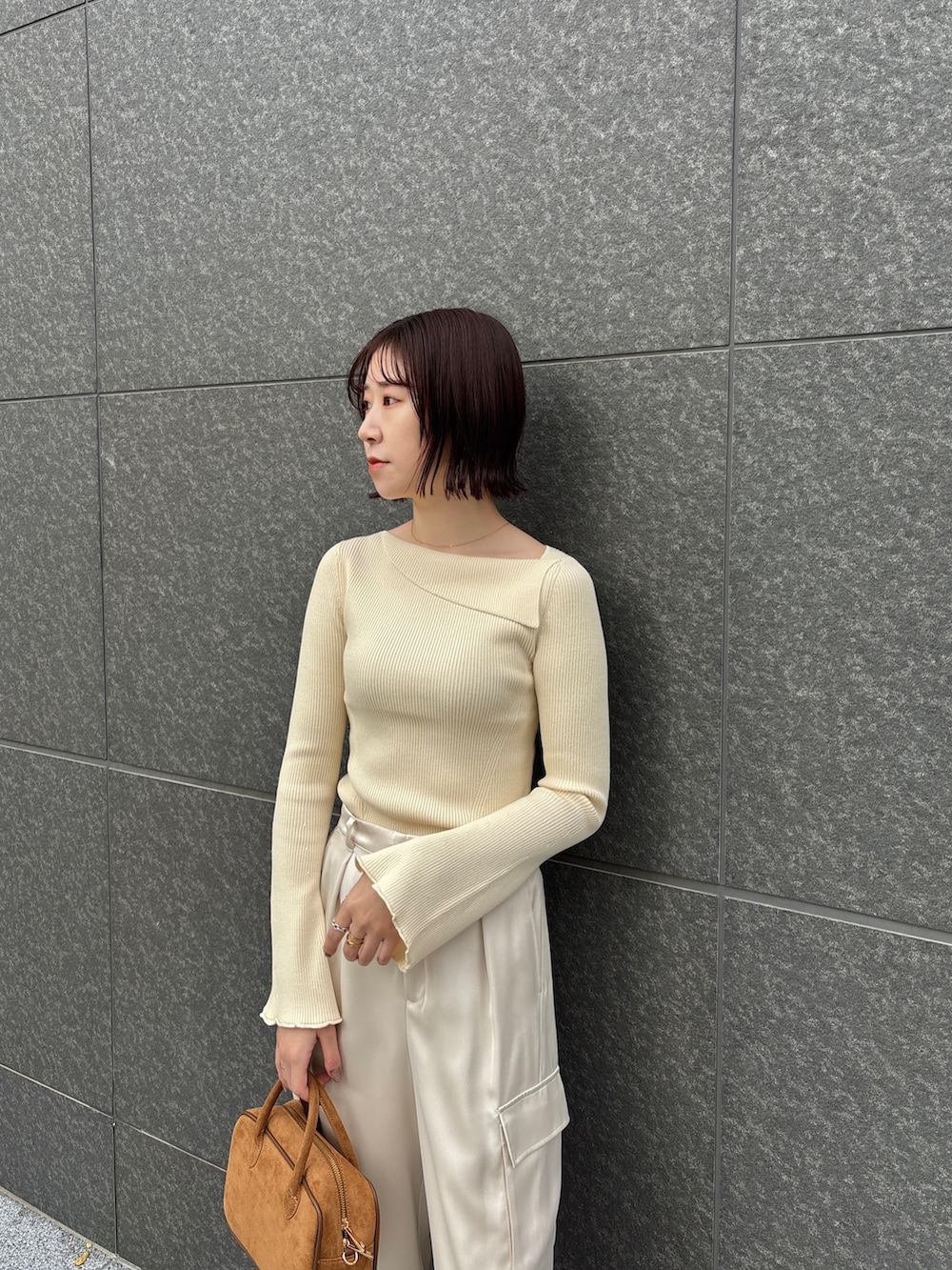 ホワイト系のカーゴパンツ、ホワイト系のニット/セーター、イエロー系のハンドバッグを着用したレディースの冬コーディネートの4枚目の写真