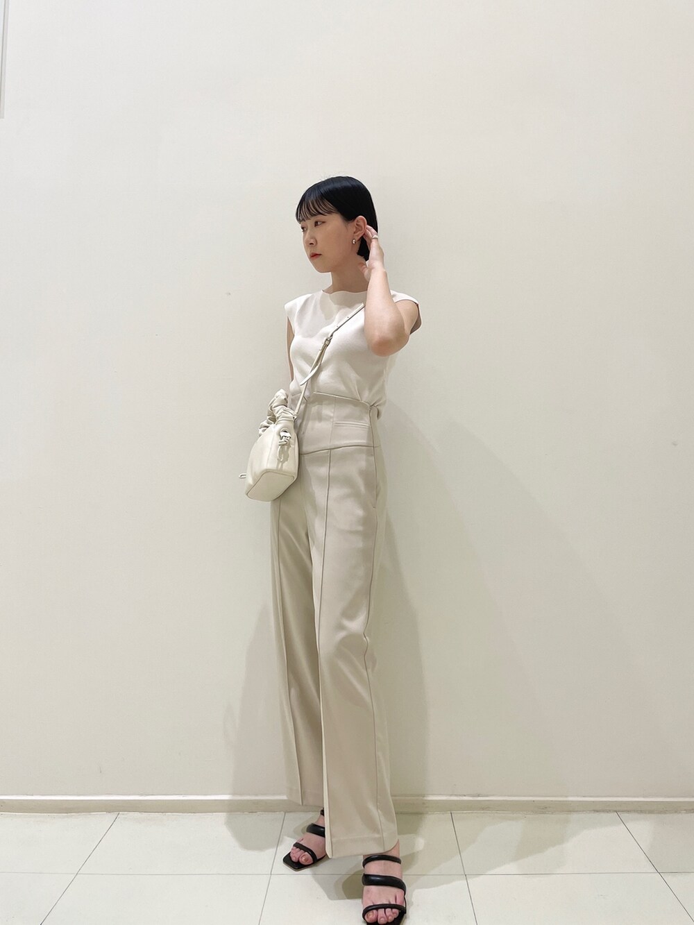 ブラック系のサンダル、ホワイト系のハンドバッグ、ホワイト系のその他パンツを着用したレディースの春コーディネートの3枚目の写真