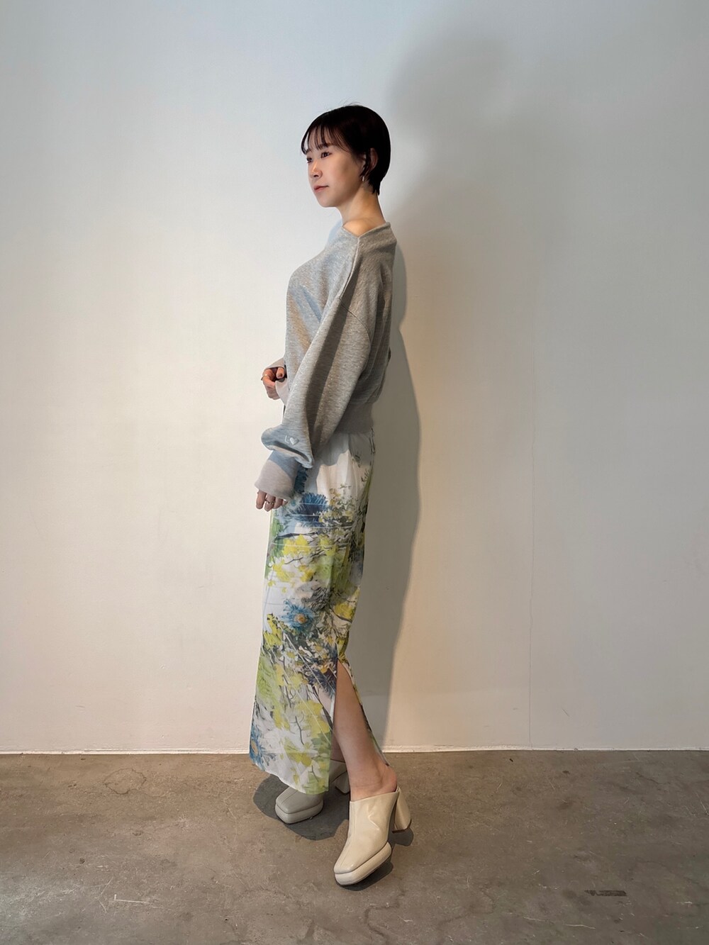 グレー系のスカート、グレー系のスウェット、ホワイト系のサンダルを着用したレディースの冬コーディネートの4枚目の写真