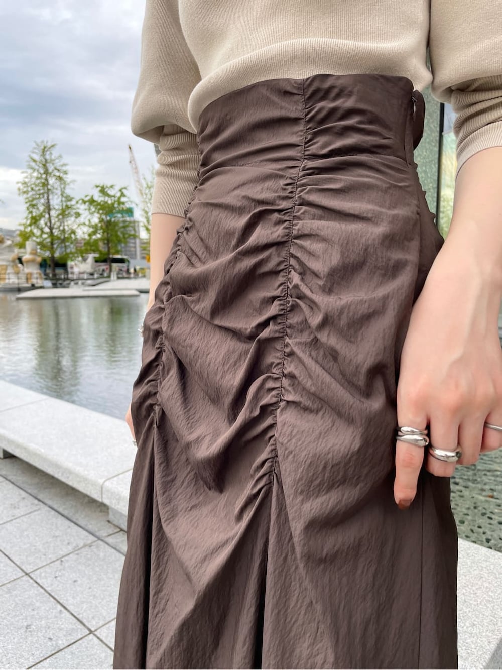 ブラック系のその他シューズ、ベージュ系のその他アウター、ブラウン系のスカートを着用したレディースの秋コーディネートの5枚目の写真