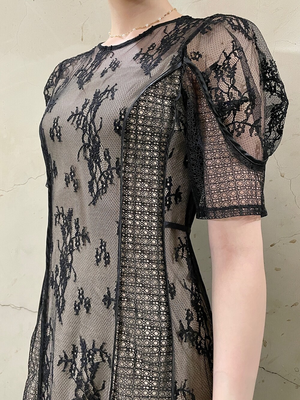 ブラック系のドレス、ゴールド系のハンドバッグ、ゴールド系のパンプスを着用したレディースの秋コーディネートの7枚目の写真