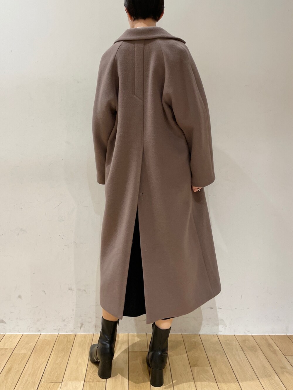 ホワイト系のニット/セーター、ブラック系のスカート、ブラック系のブーツを着用したレディースの冬コーディネートの5枚目の写真