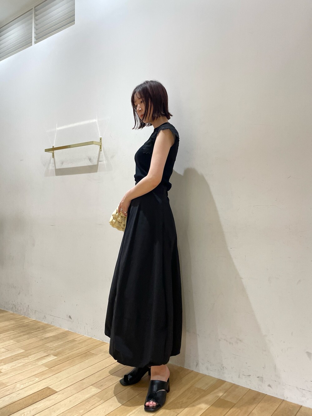 ベージュ系のハンドバッグ、ブラック系のサンダル、ブラック系のニット/セーターを着用したレディースの夏コーディネートの4枚目の写真