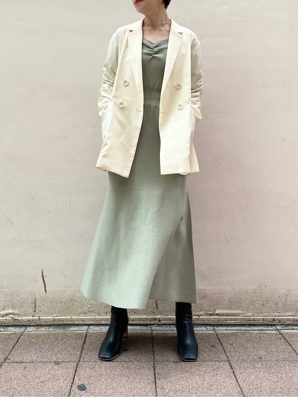 ブラック系のその他シューズ、ホワイト系のテーラードジャケット、グリーン系のワンピースを着用したレディースの冬コーディネートの2枚目の写真