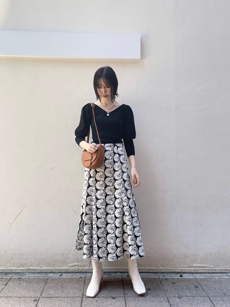 ブラック系のスカート、ブラウン系のショルダーバッグ、ホワイト系のその他シューズを着用したレディースの秋コーディネートの4枚目の写真