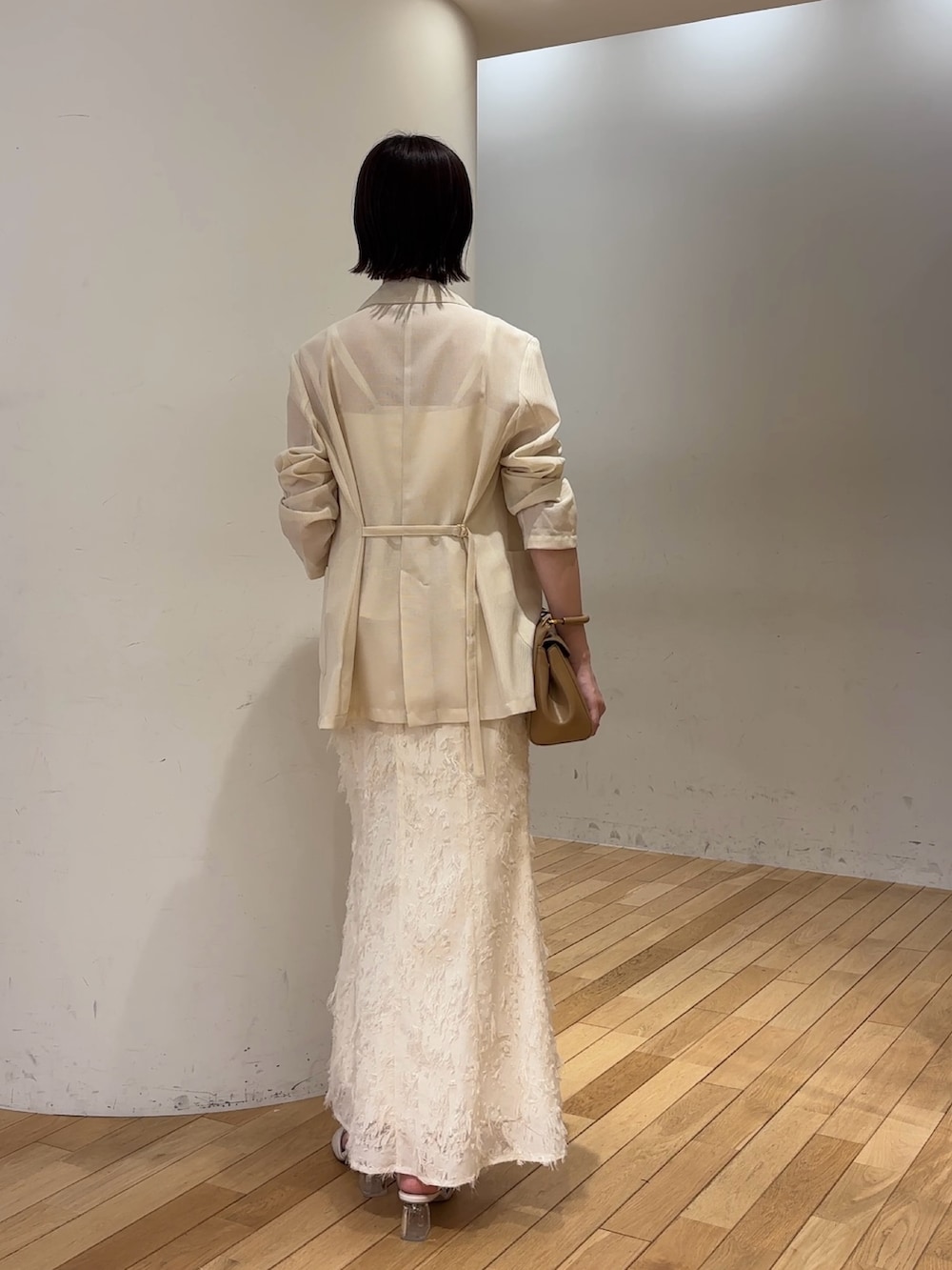 ホワイト系のスカート、ホワイト系のキャミソール、ホワイト系のテーラードジャケットを着用したレディースの夏コーディネートの4枚目の写真