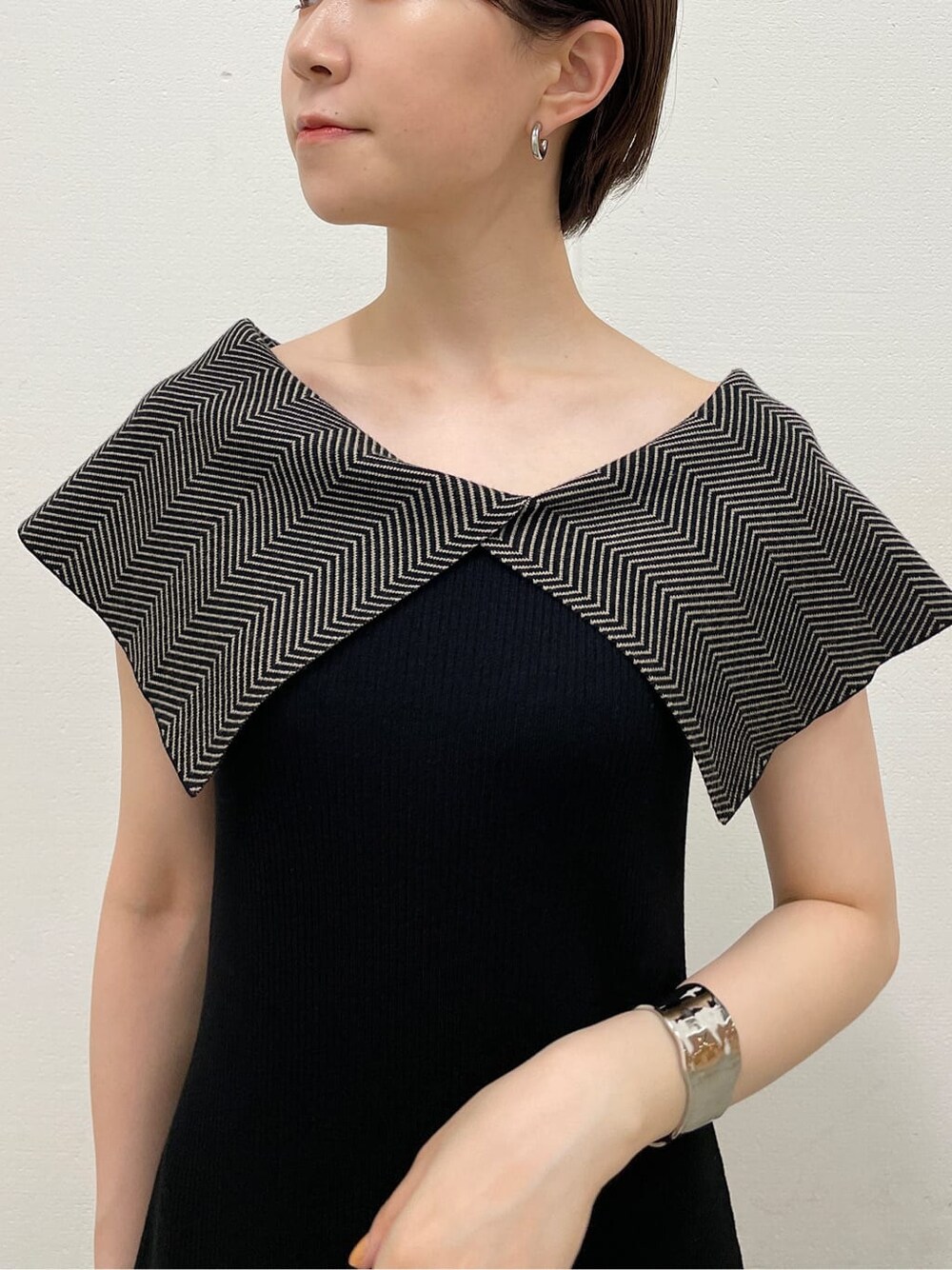 ホワイト系のサンダル、ブラック系のワンピース、シルバー系のバングル/リストバンドを着用したレディースの夏コーディネートの8枚目の写真