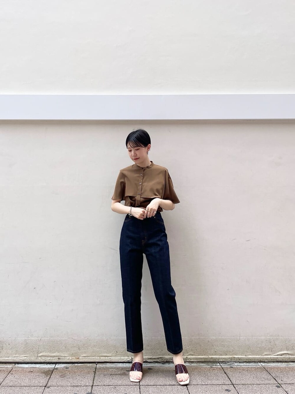 ブラウン系のサンダル、ブラウン系のシャツ/ブラウス、ブルー系のデニムパンツを着用したレディースの夏コーディネートの3枚目の写真