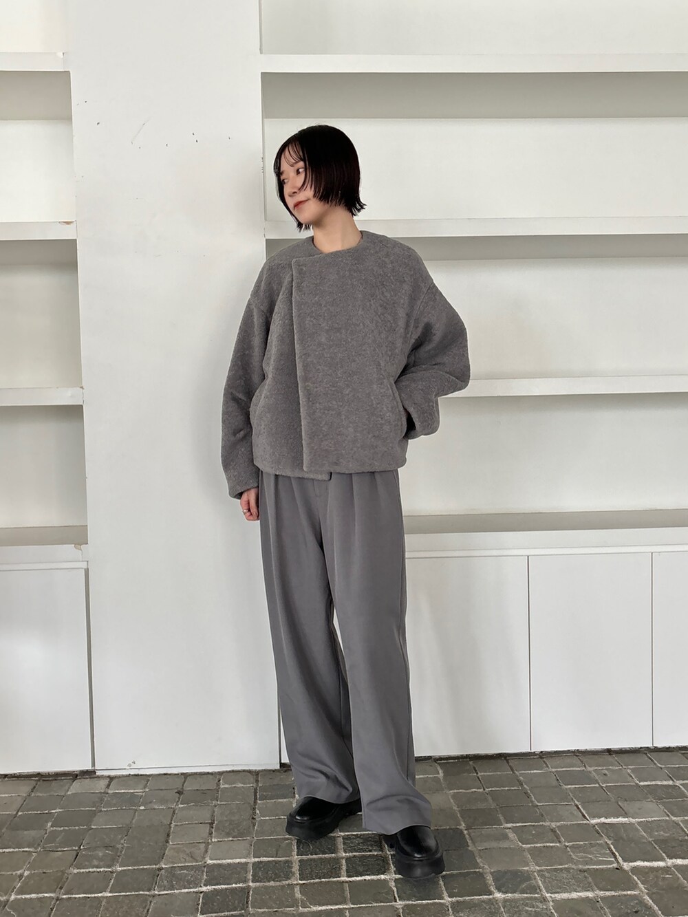 グレー系のブルゾン、グレー系のその他パンツ、ブラック系のブーツを着用したレディースの秋コーディネートの5枚目の写真