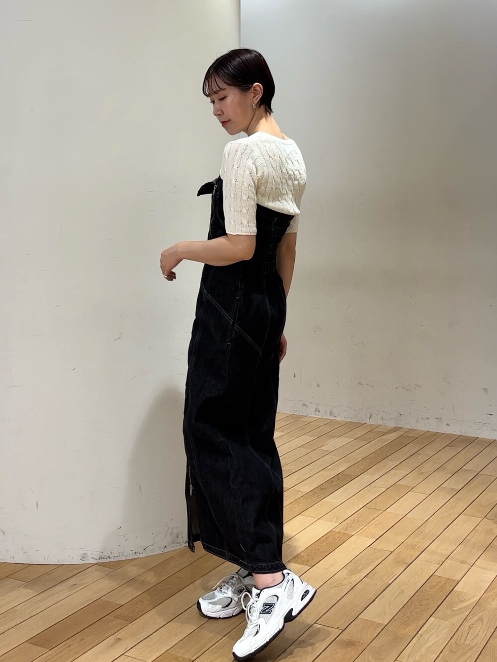 ブラック系のワンピース、ホワイト系のニット/セーターを着用したレディースの春コーディネートの3枚目の写真