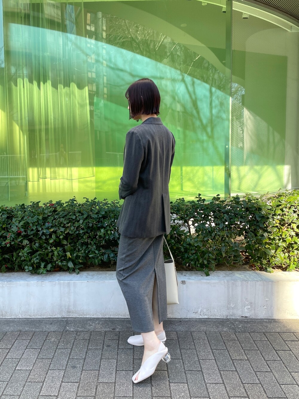 ホワイト系のパンプス、ホワイト系のショルダーバッグ、グレー系のワンピースを着用したレディースの冬コーディネートの3枚目の写真