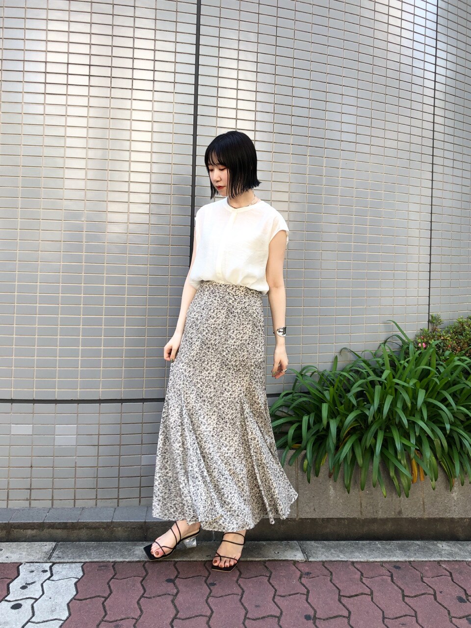 ブラック系のサンダル、ホワイト系のシャツ/ブラウス、ホワイト系のスカートを着用したレディースの夏コーディネートの2枚目の写真