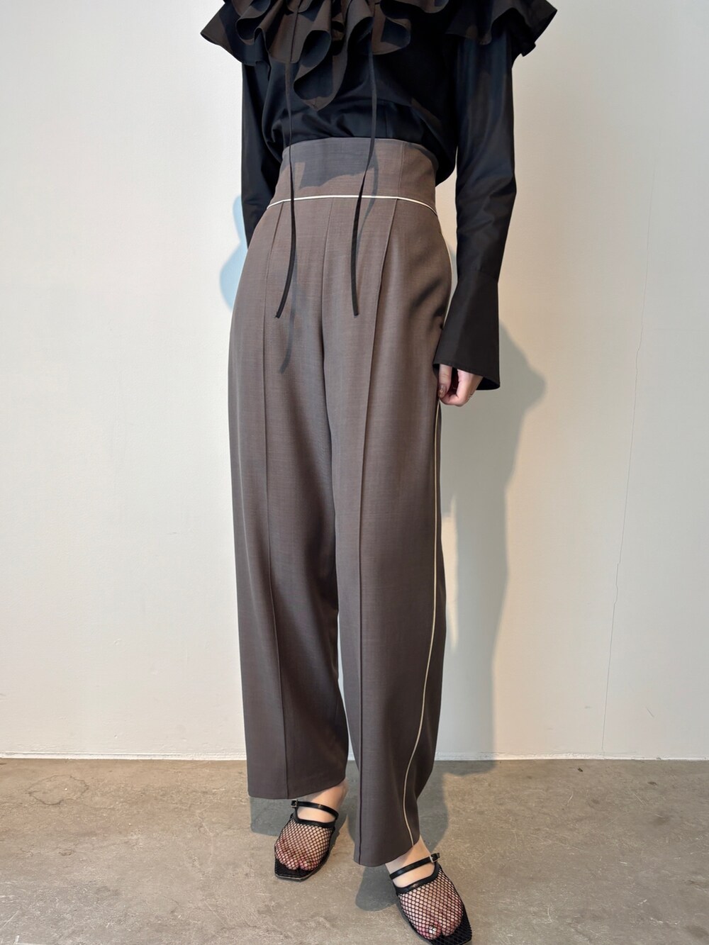 グレー系のスラックス、ブラック系のシャツ/ブラウス、ブラック系のサンダルを着用したレディースの春コーディネートの5枚目の写真