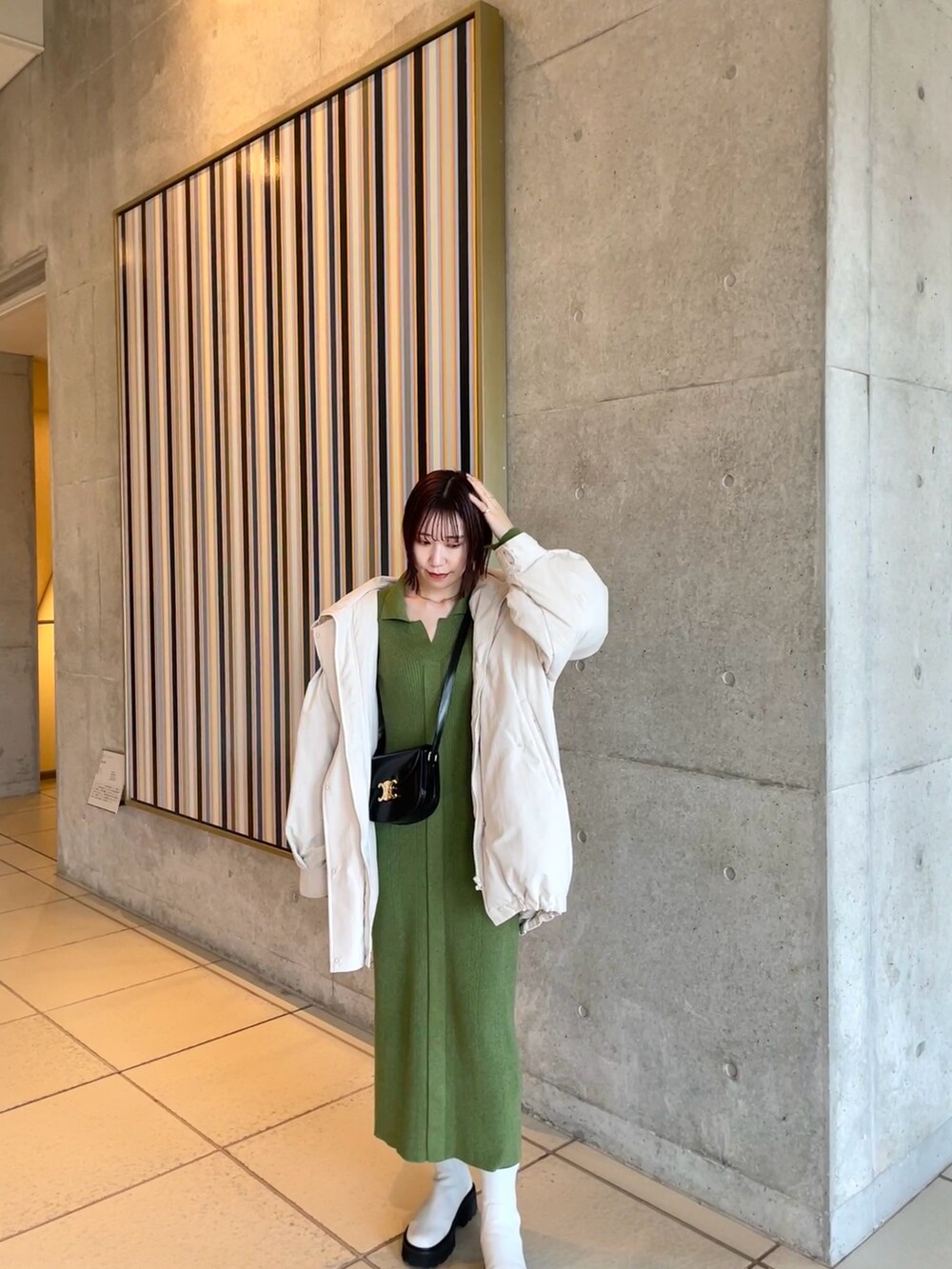 グリーン系のワンピース、ホワイト系のダウンジャケット/コートを着用したレディースの冬コーディネートの3枚目の写真