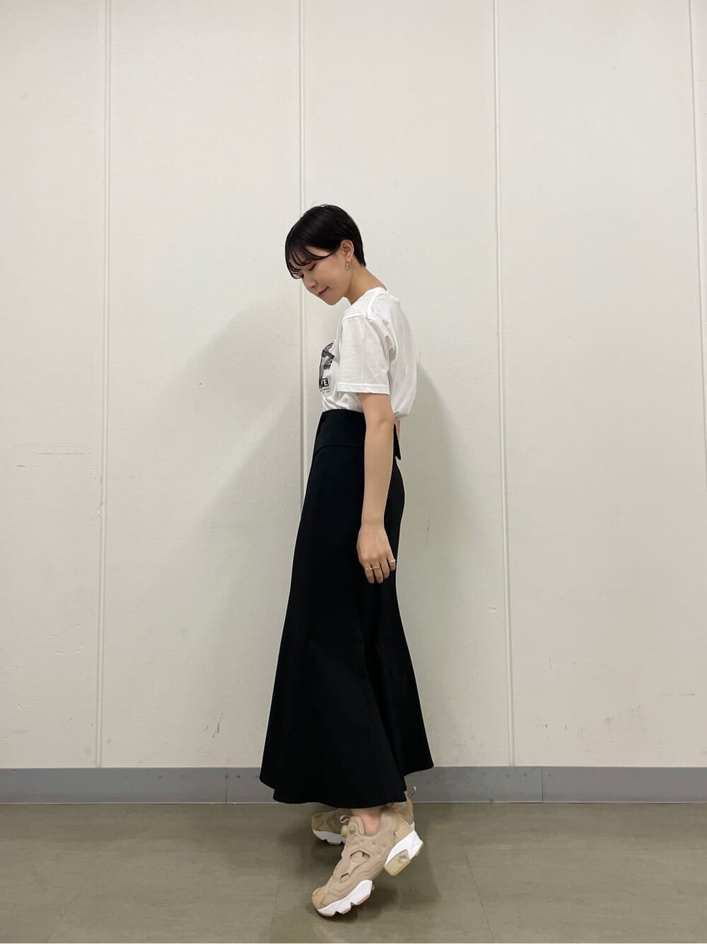 ベージュ系のスニーカー、ホワイト系のTシャツ/カットソー、ブラック系のスカートを着用したレディースの夏コーディネートの5枚目の写真