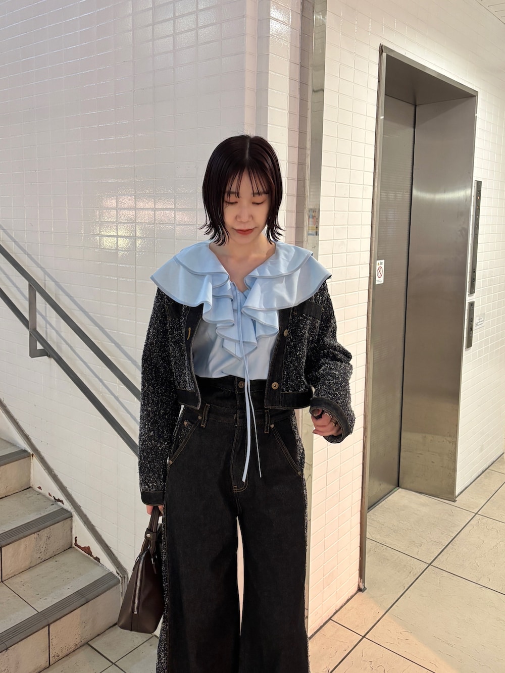 ブルー系のシャツ/ブラウス、ブラック系のデニムジャケット、ブラック系のデニムパンツを着用したレディースの冬コーディネートの2枚目の写真