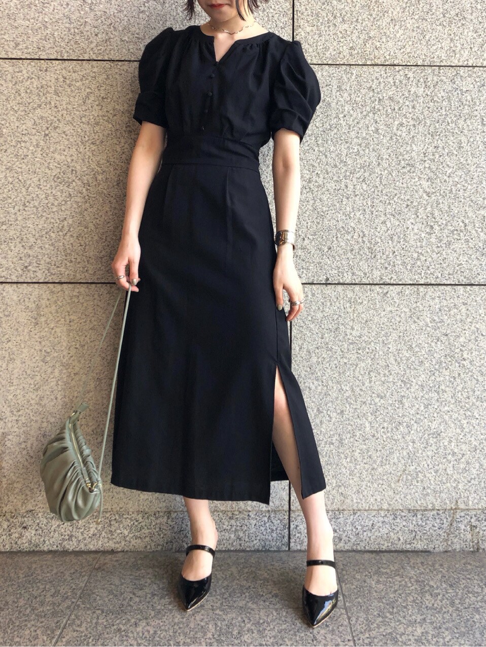 ブラック系のその他シューズ、グリーン系のハンドバッグ、ブラック系のワンピースを着用したレディースの春コーディネートの3枚目の写真