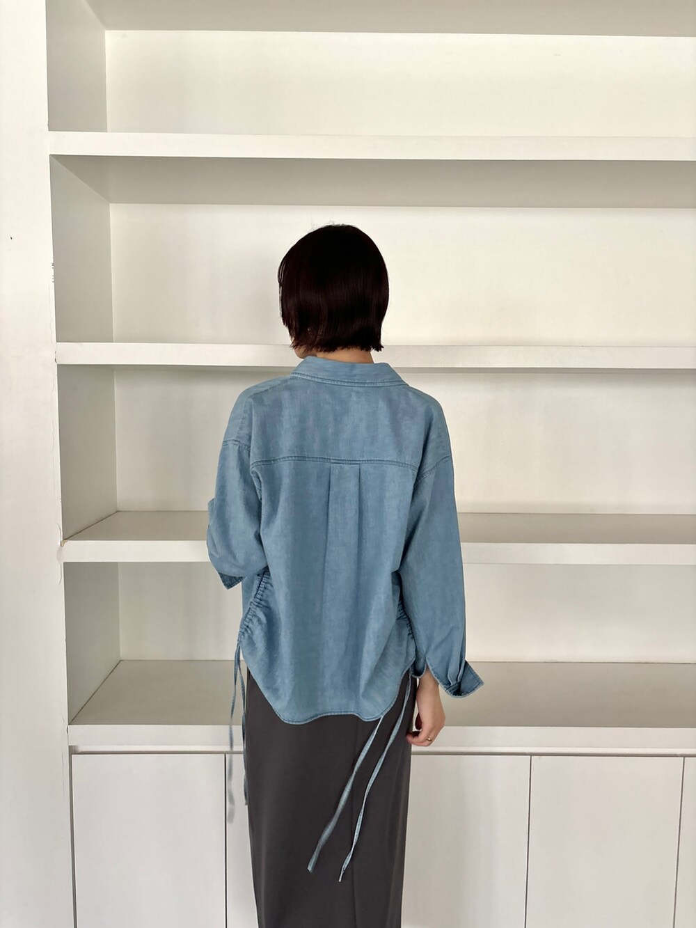 グレー系のワンピース、ホワイト系のサンダル、ブルー系のシャツ/ブラウスを着用したレディースの冬コーディネートの6枚目の写真