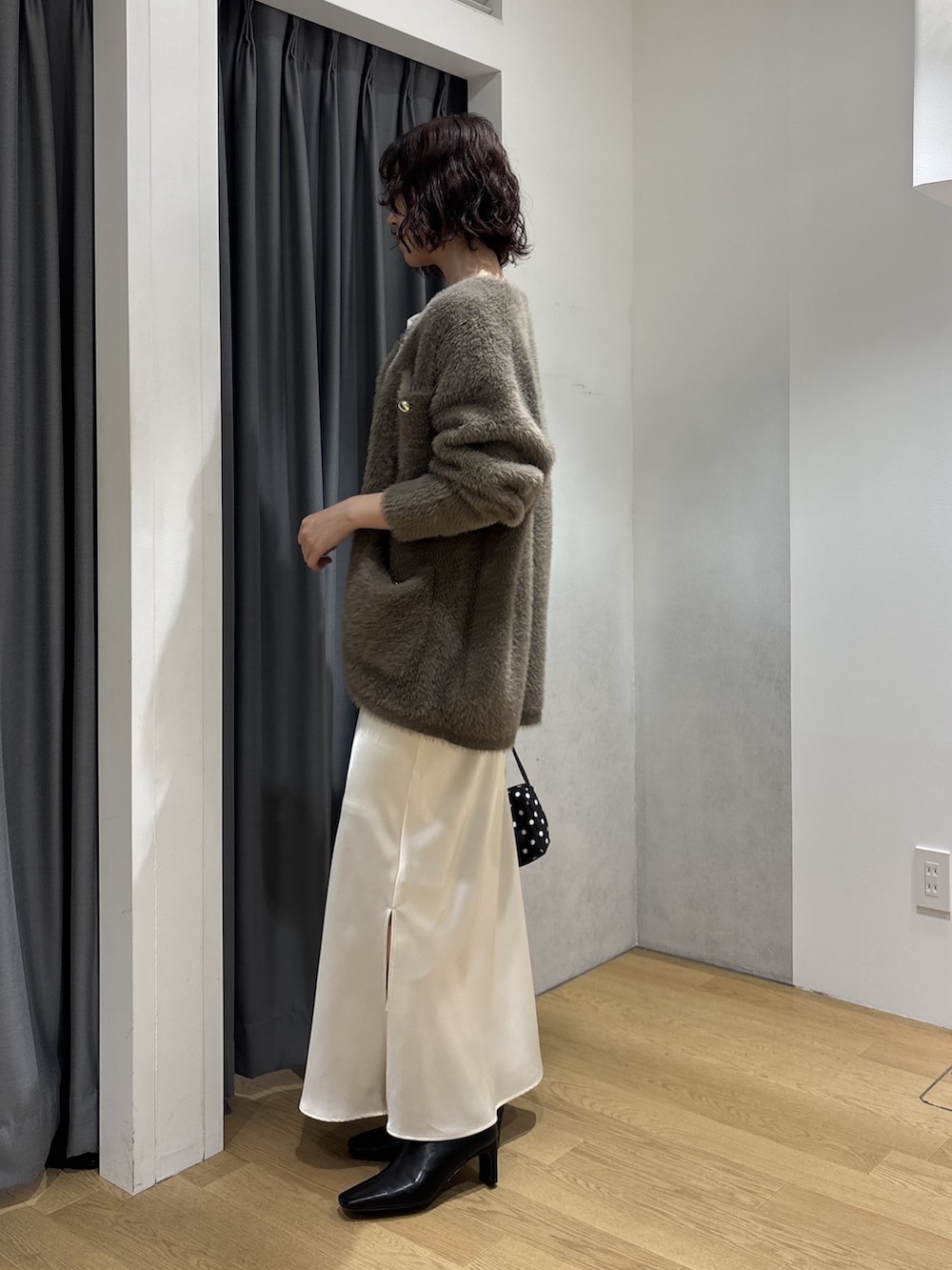 ホワイト系のスカート、ブラウン系のカーディガン/ボレロ、ホワイト系のニット/セーターを着用したレディースの秋コーディネートの3枚目の写真