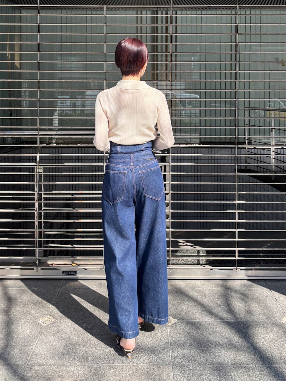 ホワイト系のTシャツ/カットソー、ブラック系のサンダル、ブルー系のデニムパンツを着用したレディースの春コーディネートの3枚目の写真