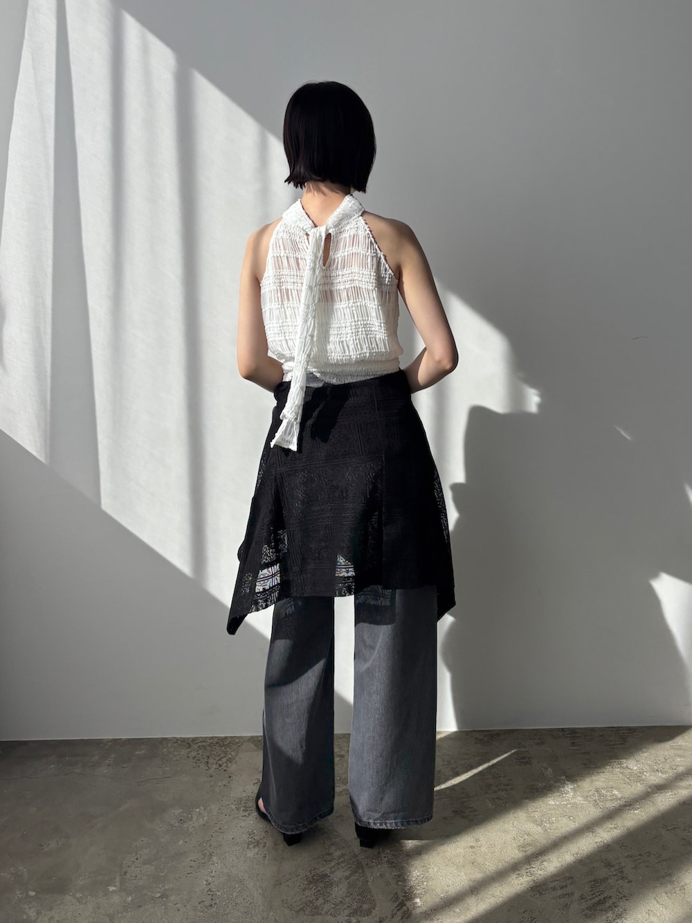 グレー系のデニムパンツ、ブラック系のパンプス、ブラック系のテーラードジャケットを着用したレディースの春コーディネートの4枚目の写真