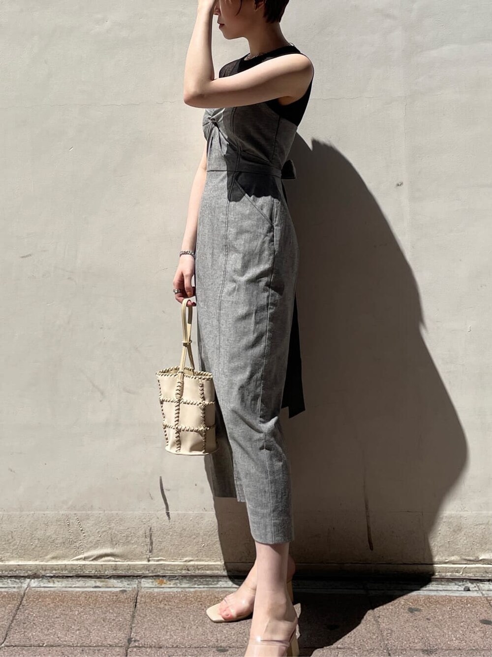 ブラック系のワンピース、その他のサンダル、ホワイト系のショルダーバッグを着用したレディースの春コーディネートの3枚目の写真