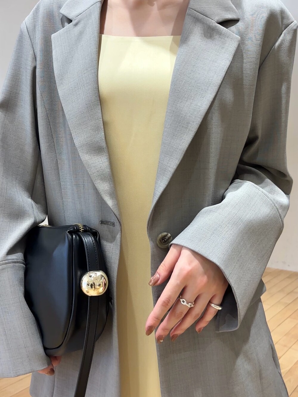 ホワイト系のワンピース、ホワイト系のテーラードジャケット、ブラック系のショルダーバッグを着用したレディースの春コーディネートの6枚目の写真