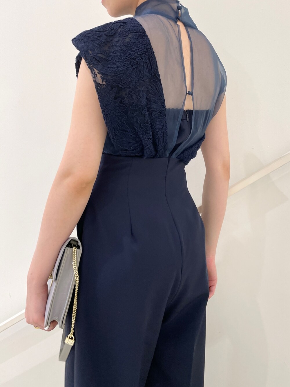 ブルー系のパンツドレス、グレー系のクラッチバッグ、グレー系のパンプスを着用したレディースの冬コーディネートの9枚目の写真