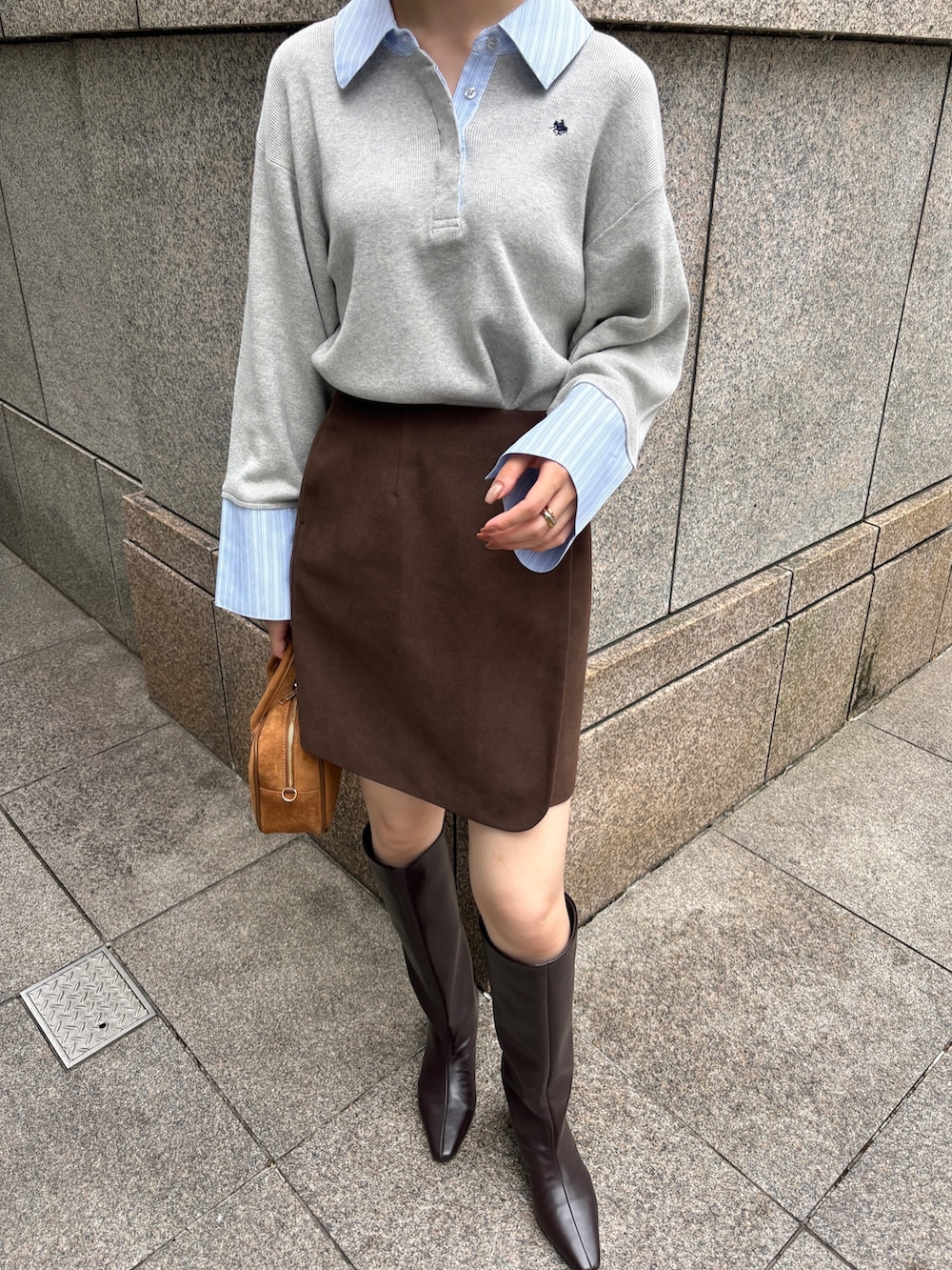 ブラウン系のスカート、グレー系のニット/セーター、イエロー系のハンドバッグを着用したレディースの秋コーディネートの4枚目の写真