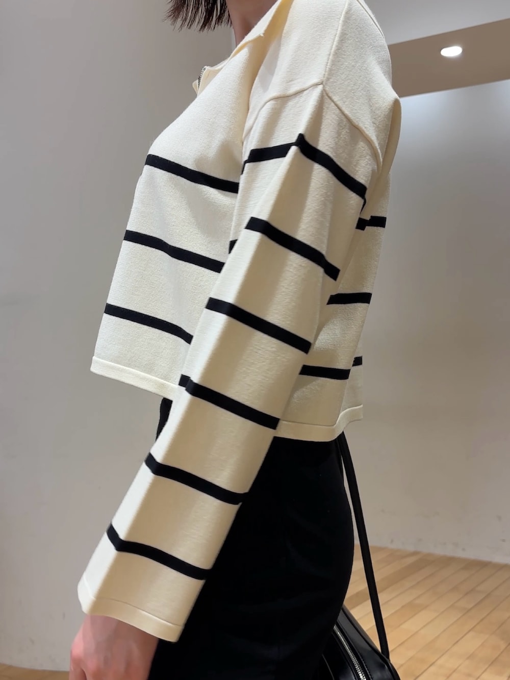 ホワイト系のニット/セーター、ブラック系のスカート、ブラック系のブーツを着用したレディースの冬コーディネートの5枚目の写真