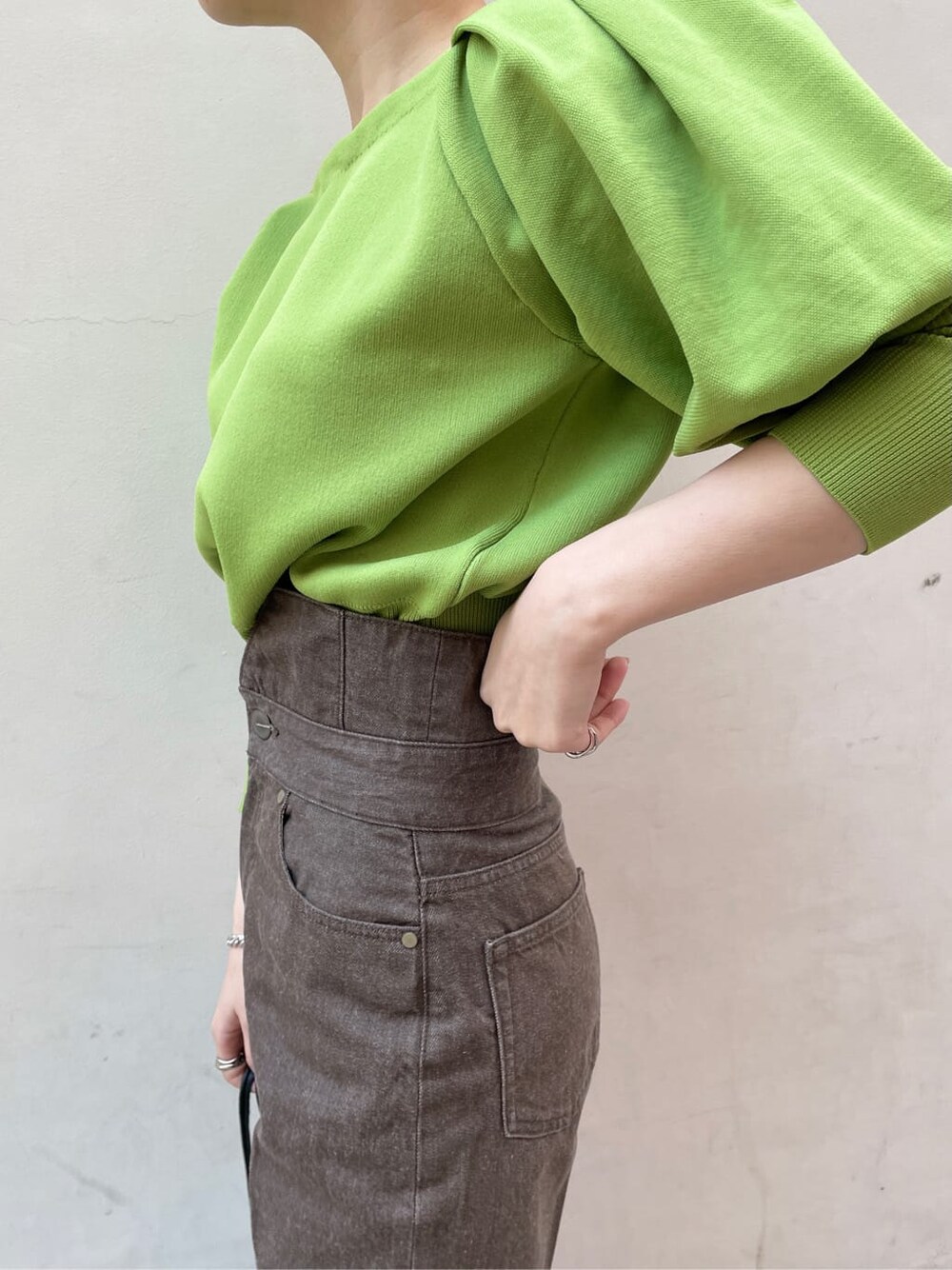 ブラック系のその他シューズ、ブラック系のハンドバッグ、グリーン系のニット/セーターを着用したレディースの冬コーディネートの5枚目の写真