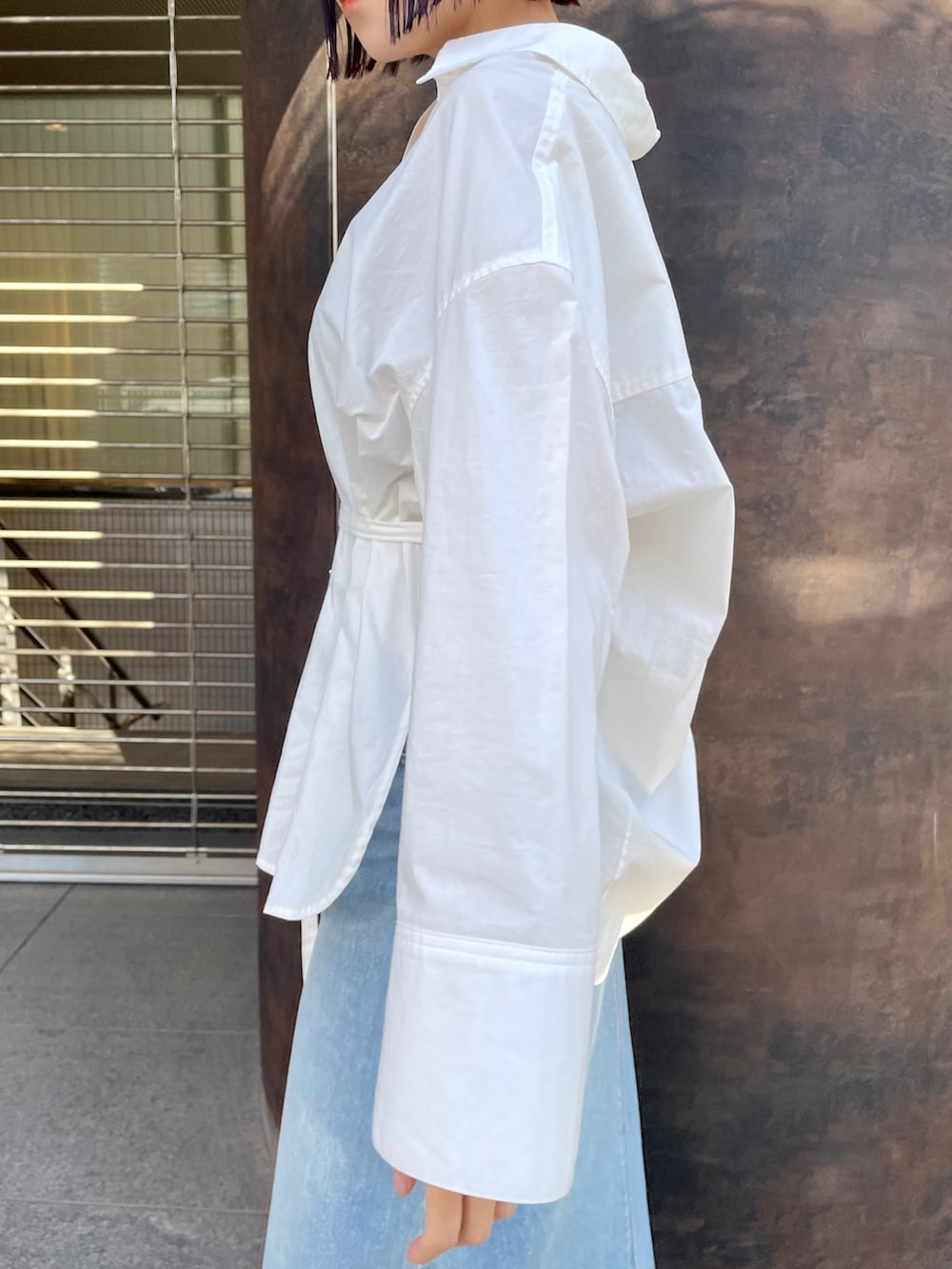 ホワイト系のシャツ/ブラウス、グリーン系のデニムスカート、ホワイト系のスニーカーを着用したレディースの春コーディネートの7枚目の写真