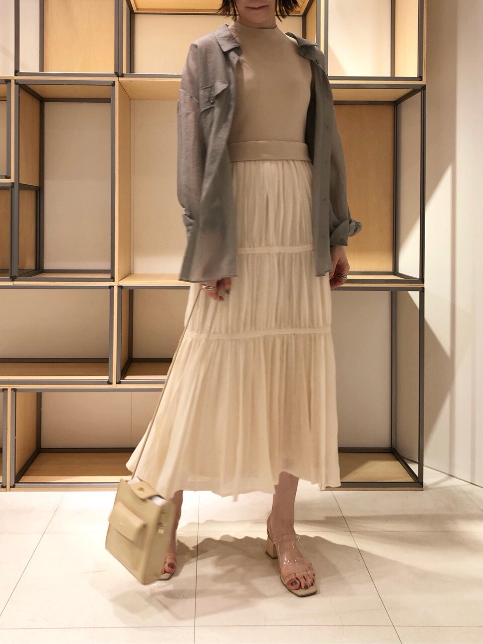 ベージュ系のハンドバッグ、ベージュ系のブルゾン、ベージュ系のワンピースを着用したレディースの春コーディネートの7枚目の写真