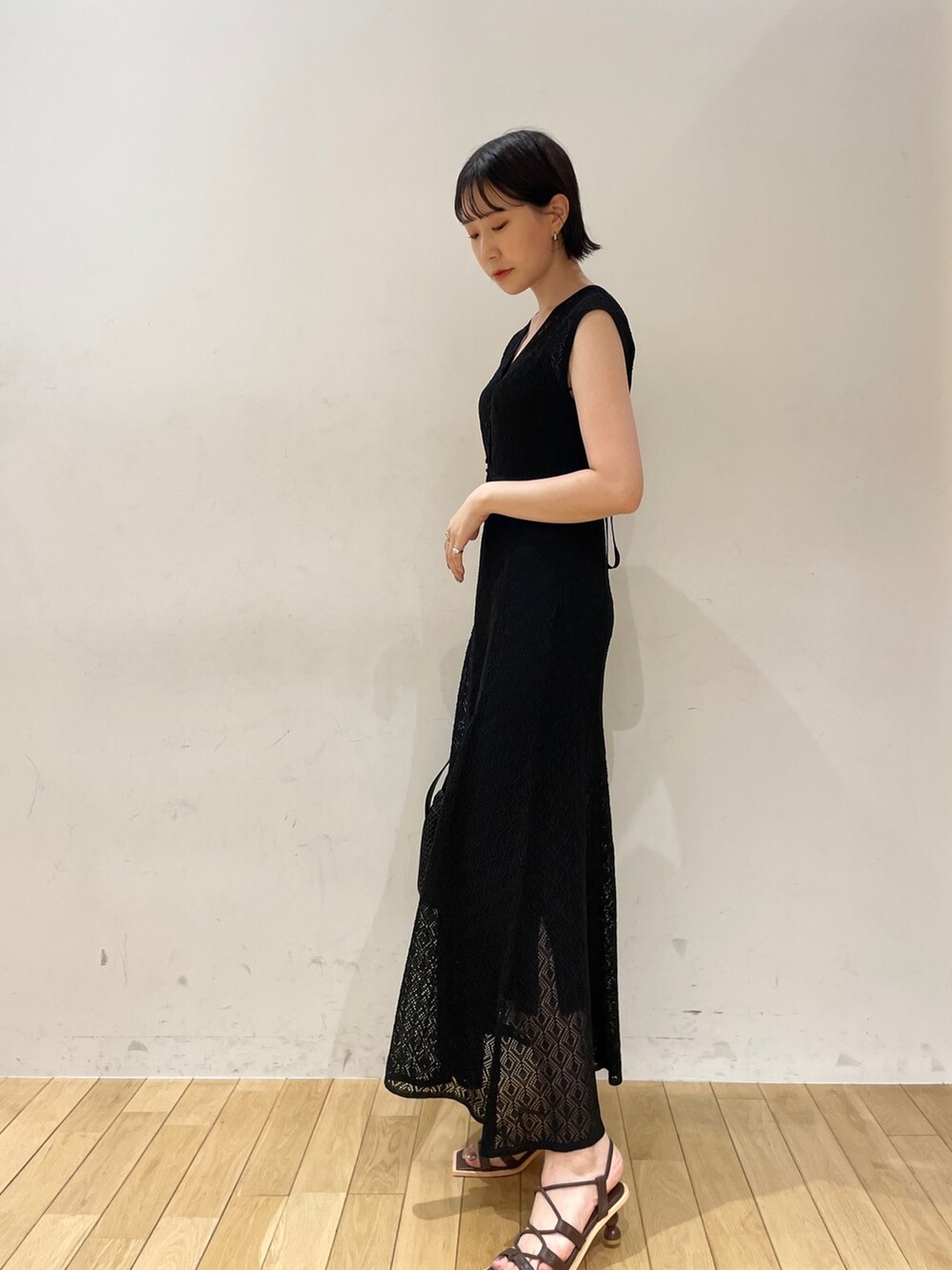 ブラック系のワンピース、ブラック系のハンドバッグ、ブラウン系のサンダルを着用したレディースの夏コーディネートの5枚目の写真