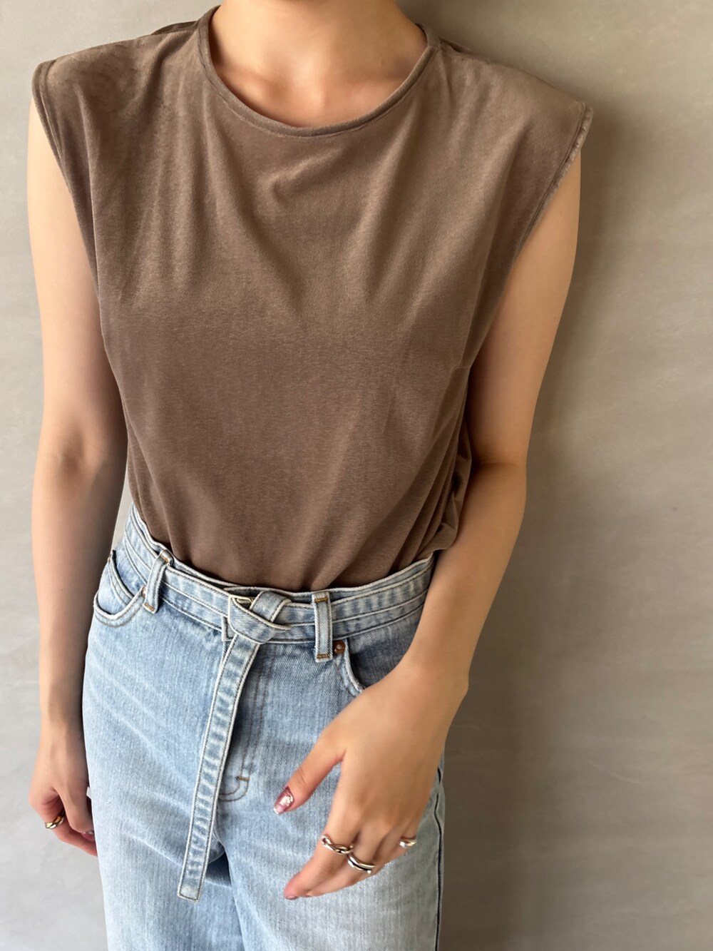 ブルー系のデニムパンツ、ブラック系のサンダル、ブラウン系のTシャツ/カットソーを着用したレディースの夏コーディネートの5枚目の写真