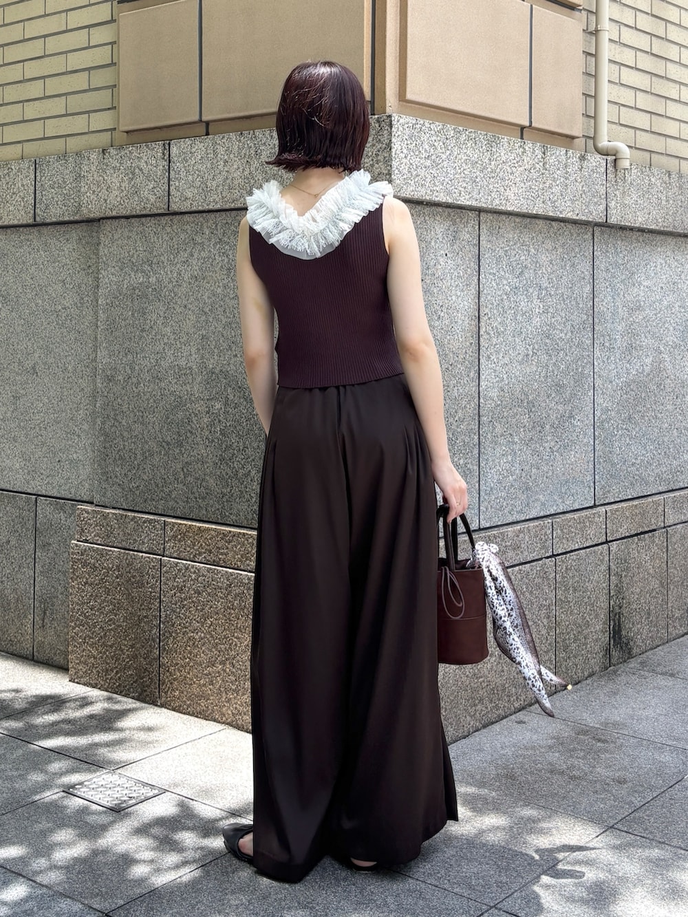 ブラウン系のその他パンツ、ブラウン系のハンドバッグ、ブラウン系のサンダルを着用したレディースの夏コーディネートの3枚目の写真