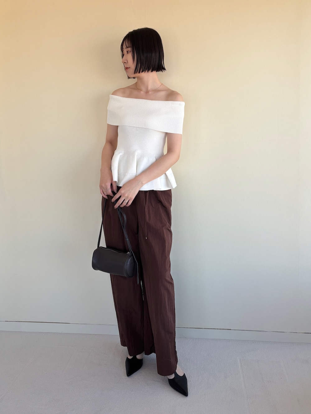 ブラウン系のその他パンツ、ブラック系のパンプス、ホワイト系のニット/セーターを着用したレディースの春コーディネートの2枚目の写真