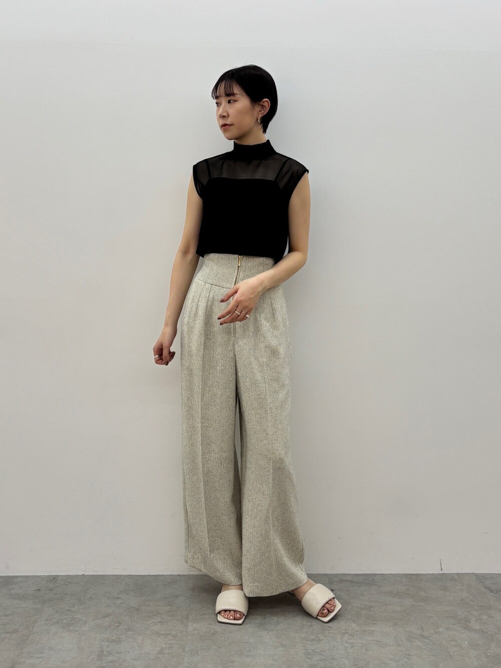 ホワイト系のその他パンツ、ホワイト系のサンダル、ブラック系のTシャツ/カットソーを着用したレディースの春コーディネートの2枚目の写真