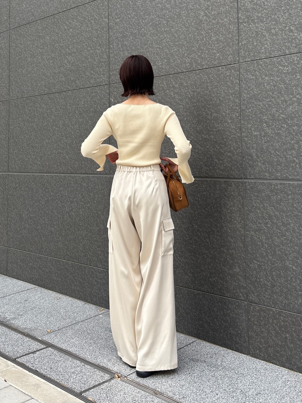 ホワイト系のカーゴパンツ、ホワイト系のニット/セーター、イエロー系のハンドバッグを着用したレディースの冬コーディネートの3枚目の写真